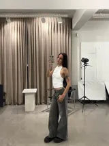 Pantalón de jean gris con efecto lavado, de corte recto y tiro bajo. Presenta costuras verticales decorativas en el frente y bolsillos tipo cargo frontales.