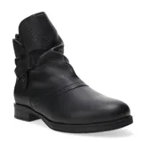 Botas de caña media confeccionadas en cuero negro, con interior forrado en corderito sintético color crema. Presentan un diseño con detalle de tira lateral con hebilla metálica y suela plana con pequeño tacón.