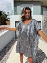 Túnica tipo poncho de corte holgado y escote en V, completamente cubierta de lentejuelas plateadas brillantes.