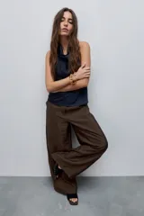 Pantalón wide leg de tiro alto, confeccionado en tela ligera de caída fluida y brillo sutil.