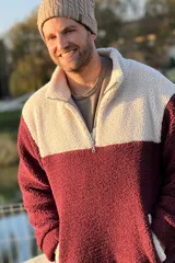 Buzo de polar con cierre a mitad del pecho, color bordó en la parte inferior y blanco en la parte superior.