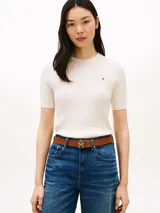 Sweater de punto trenzado fino de color blanco, confeccionado en puro algodón, con cuello redondo y mangas cortas. Presenta un pequeño logo bordado en el pecho.