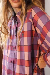 Camisa de manga larga con cuello clásico y cierre frontal de botones. Presenta un diseño de rayas verticales verdes y blancas con un estampado lineal de pequeñas flores rojas.