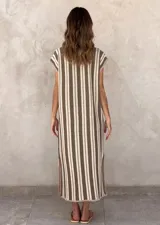 Vestido midi de punto sin mangas, con cuello en V acanalado y diseño de rayas verticales en tonos beige y marrón. Presenta aberturas laterales decoradas con botones a lo largo del ruedo.