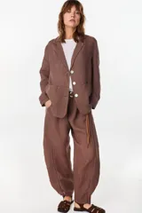 Blazer de lino italiano color beige, de botonadura sencilla, solapas clásicas, bolsillos de parche y detalle de puños tableados.