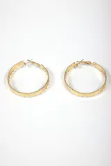 Par de aros argolla grandes de metal plateado, con textura estriada o facetada en toda su superficie. Cierre tipo gancho.