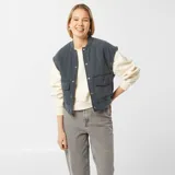 Campera bomber azul petróleo acolchada con cuello redondo, cierre con botones a presión, bolsillos con solapa y puños y cintura elásticos.