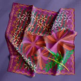 Pañuelo cuadrado de seda premium con estampado de flores en tonos púrpura, naranja y verde. Diseño exclusivo de la marca, edición limitada "Poetas rioplatenses".