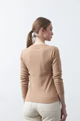 Remera de manga larga color blanco, de calce entallado, con cuello redondo a la base y costuras verticales decorativas que estilizan la silueta.