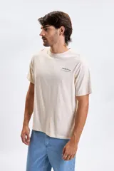 Remera de manga corta en color gris claro, con cuello redondo y estampa pequeña en el pecho con texto alusivo.