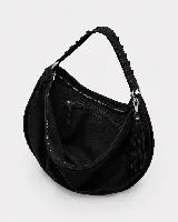 Bolso tipo hobo de gran tamaño, confeccionado en gamuza negra con detalles de costuras artesanales y tientos decorativos en los bordes. Cuenta con un asa trenzada con pespuntes a mano y cierre superior.