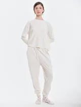 Pantalón de dormir tipo jogging confeccionado en plush acanalado de tacto suave. Presenta cintura elastizada con cordón ajustable, bolsillos laterales y puños elastizados en los tobillos.