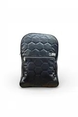 Mochila color negro con diseño matelasseado de hexágonos que simula un balón de fútbol. Cuenta con un bolsillo frontal con cierre metálico y el logo de la marca bordado en color blanco.