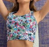 Top deportivo corto con estampado floral en tonos celeste, rosa, verde y blanco. Diseño sin costuras y espalda nadadora.