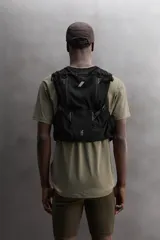 Chaleco deportivo técnico color verde con detalles en marrón, múltiples bolsillos con cierre y ajuste lumbar con cordón elástico.