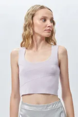 Top negro sin mangas con escote cuadrado, confeccionado en tejido con leve brillo y costuras asimétricas en el frente.