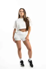 Conjunto deportivo blanco compuesto por un top corto de mangas cortas y shorts ajustados con bolsillos laterales.