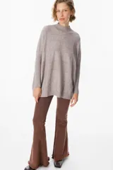 Sweater crudo de punto con cuello alto y mangas largas con puños ajustados.