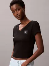 Remera de Calvin Klein confeccionada en punto de algodón elástico con textura de canalé fino. Presenta un diseño de corte slim, cuello en V, manga corta y una insignia con el logo de la marca en el pecho.