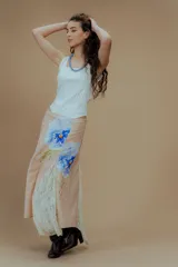 Falda larga color beige con estampado de flores azules y gajos de encaje.
