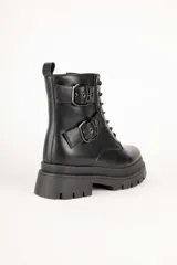 Borcegos negros de caña baja en símil cuero, con apliques de hebillas metálicas y cierre lateral. Plataforma de 5cm de alto.