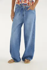 Pantalón jean de corte ancho y tiro medio, confeccionado en 100% algodón. Presenta cintura ajustable con cordón y detalles deshilachados en la parte superior.