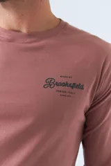 Remera de manga larga color ladrillo con logo estampado en el pecho.