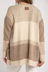Cardigan abierto de punto con diseño de bloques de color en tonos beige, marrón y bordó. Presenta mangas largas, corte recto y bolsillos frontales aplicados.