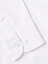 Camisa blanca de Tommy Hilfiger de corte slim fit, manga larga y cuello abotonado. Tiene el logo de la marca bordado en el pecho.