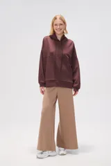 Canguro negro holgado con capucha y cordones ajustables, mangas largas y bolsillos laterales.