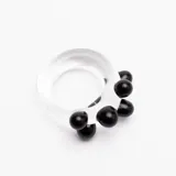 Anillo artesanal de vidrio transparente con diseño irregular, decorado con esferas de vidrio negro aplicadas en un lateral.