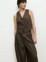 Chaleco marrón con escote en V, cierre frontal con botones y un bolsillo pequeño en el pecho.