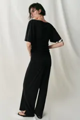 Pantalón largo color bordó, confeccionado en crepe fluido, con tiro alto, cintura elástica y diseño de pierna ancha.