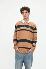 Remera polo de manga larga con diseño de rayas horizontales rojas sobre fondo blanco, cuello camisero tostado con media cartera de botones y puños ajustados.