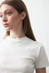 Remera de manga corta con cuello redondo a la base, de calce clásico y diseño minimalista con ruedo redondeado.