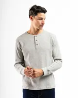 Remera tipo henley de manga larga confeccionada en tejido de algodón con textura mini piqué. Presenta un cierre frontal con tres botones y puños ajustados en las mangas.