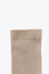 Par de calcetines de caña media, color beige claro, con textura acanalada (rib).
