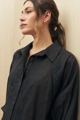 Camisa color beige con bordados florales, cuello clásico, cierre con botones y mangas 3/4 abullonadas.