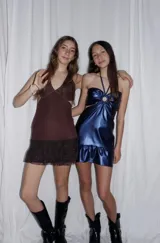 Vestido corto azul metalizado con diseño cut-out, argolla central en el busto, tirantes halter y falda con volado en el ruedo.