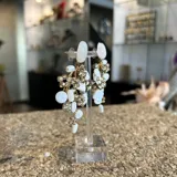 Aros colgantes hechos a mano con cristales dorados y nácar blanco. Se ajustan con perforación.
