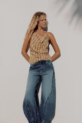 Jeans de tiro medio confeccionados en denim azul con efecto deslavado, corte holgado con diseño de volumen abullonado en las piernas y bajo con puño elástico. Cuentan con trabillas, bolsillos delanteros y traseros, y costuras decorativas marcadas.