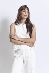 Blusa negra sin mangas, de corte recto y escote redondo, con detalles de bordados contrastantes en color blanco en los bordes y costados.