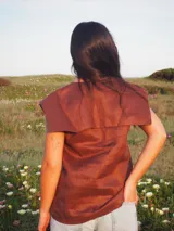 Blusa sin mangas de lino color blanco, con cuello marinero grande y detalles de encaje en el cuello y a lo largo de la botonadura frontal.