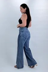 Pantalón jean wide leg de tiro alto en color azul, con diseño de costuras diagonales contrastantes en el frente y corte amplio en las piernas.