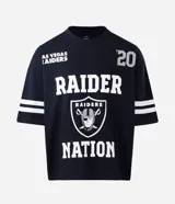 Remera deportiva de corte oversized, color negro, con estampado gráfico en la espalda del equipo Las Vegas Raiders de la NFL. Presenta cuello redondo, mangas cortas con detalles de rayas blancas y logo de la NFL en la parte superior trasera.