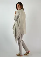 Camisola color beige con calados circulares, mangas 3/4 con trabilla y cuello con solapa.