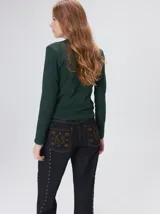 Remera de manga larga con cuello a la base, confeccionada en tejido de punto acanalado color beige. Presenta un logo bordado en el centro del pecho.