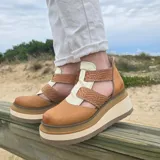 Zapatos de cuero con plataforma alta en tonos marrones y beige, diseño de tiras cruzadas en el empeine y laterales abiertos.