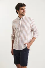 Camisa de lino a rayas verticales color beige y blanco, de manga larga con cuello abotonado y bolsillo en el pecho.