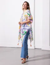 Kimono de manga amplia japonesa con estampado abstracto multicolor sobre fondo blanco. Presenta terminaciones con borlas en el ruedo.